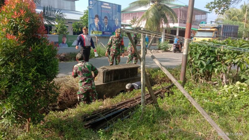 Babinsa Sekura Gotong Royong Bersama Forkopimcam dan Masyarakat Bersihkan Halaman Kantor Camat Teluk Keramat
