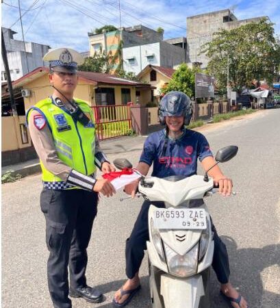 Personel Polres Labuhanbatu Selatan Bagikan Bendera Merah Putih Sambut Hari Kemerdekaan Republik Indonesia Ke-80