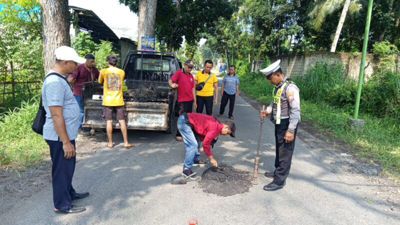 Satlantas Polsek Rogojampi Bersama Pemerintah Desa,Lakukan Penambalan Jalan Rusak Berlubang di Desa Gladag 